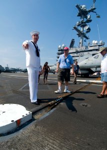 US Navy 100905-N-0754Y-033 viation Boatswain's Mate (Equipment) 1st Class Sean Valis explains the function of the arresting gear on the flight deck