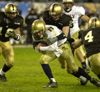 US Navy 031206-N-9693M-520 Navy quarterback Craig Candeto is wrapped up by an Army defender during the 104th Army Navy Game