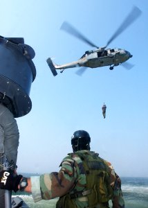 US Navy 030826-N-4374S-022 A member of Special Boat Team 20 (SBT-20) keeps a close watch during a recovery evolution by an MH-60S Kighthawk assigned to Chargers of Helicopter Combat Support Squadron SIX (HC-6)