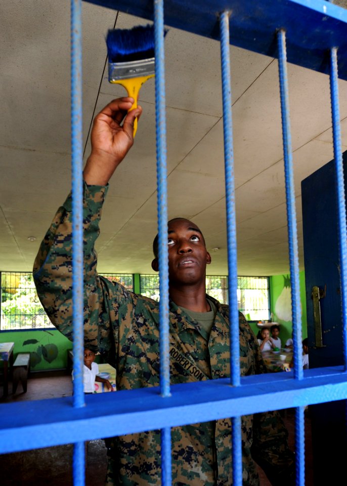 US Navy 100825-N-4153W-497 Lance Cpl. Joseph Robertson paints the bars on the window of a local school during a community service event