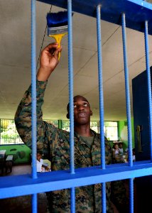 US Navy 100825-N-4153W-497 Lance Cpl. Joseph Robertson paints the bars on the window of a local school during a community service event