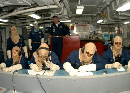 US Navy 030930-N-8955H-006 USS Blue Ridge (LCC 19) Commanding Officer Capt. J. Stephen Maynard (standing background) evaluates the damage control status board in the ship's Damage Control Central while phone talkers send and r