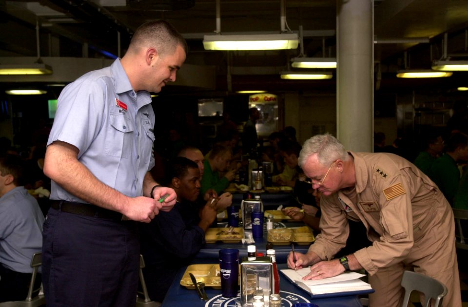 US Navy 030825-N-1577S-003 Commander U.S. Naval Forces Fifth Fleet Vice Admiral Timothy J. Keating autographs a book for Intelligence Specialist Chief (select) Mike McKay