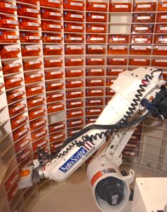 US Navy 030819-N-9593R-088 he Autoscript III, prescription filling robot, picks up a bin of medication at the National Naval Medical Center in Bethesda, Md