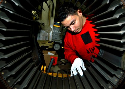 US Navy 030930-N-7090S-001 Aviation Ordnanceman 2nd Class Elijah L. Rhodes from Baltimore, Md. cleans the inside drum palette of a M-61 20 MM