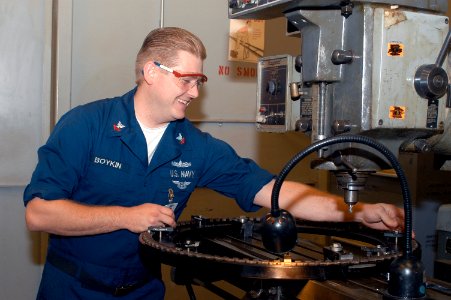 US Navy 031007-N-8770A-002 Machinist Repairman 2nd Class Sean Boykin tightens bolts on a positioning ring for motors within the Aviation Intermediate Maintenance Department