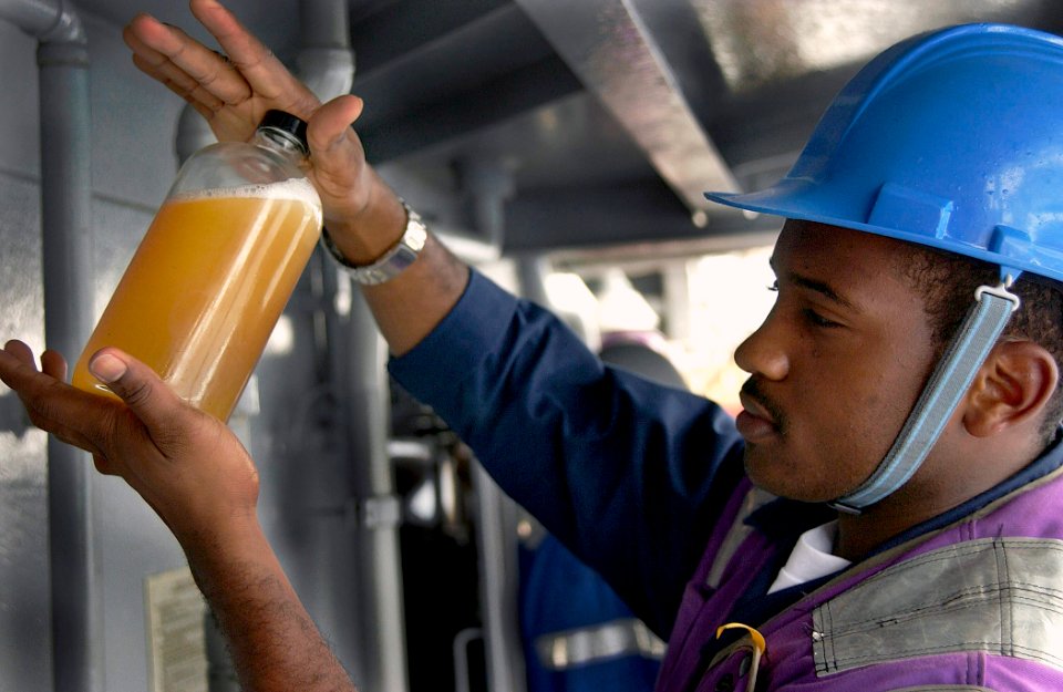 US Navy 030908-N-5471P-008 Gas Turbine System Mechanic Gene Noel checks a fuel sample aboard USS Philippine Sea (CG 58) before taking it to the oil lab during a replenishment at sea (RAS) with the military supply ship, USNS Sup