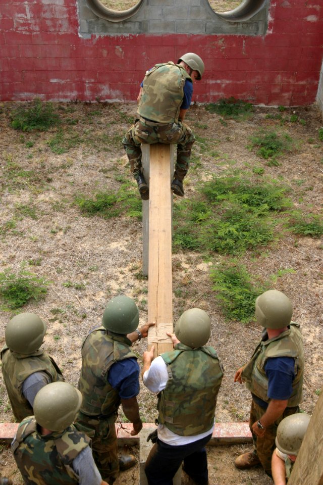 US Navy 030822-N-3228G-014 Chief Electronics Technician (select) Brian Audiss, assigned to USS Reuben James (FFG 57), carefully inches his way down a plank on the leadership reaction course