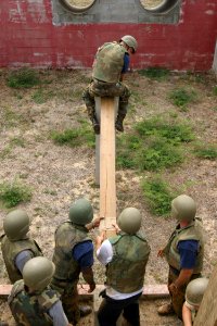 US Navy 030822-N-3228G-014 Chief Electronics Technician (select) Brian Audiss, assigned to USS Reuben James (FFG 57), carefully inches his way down a plank on the leadership reaction course