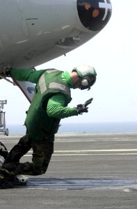 US Navy 030715-N-9319H-004 A Nimitz crewmember prepares an E-2C Hawkeye for launch from the flight deck aboard USS Nimitz (CVN 68)