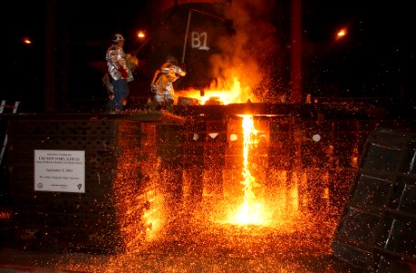 US Navy 030909-N-9954T-002 Workers pour steel, recycled from the World Trade Center, into a mold, which will form the bow stem of the Amphibious Transport Dock ship USS New York (LPD 21)