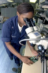 US Navy 031014-N-2143T-003 Electronics Technician 3rd Class Ebony Franklin from Durham, N.C., solders a faulty circuit card