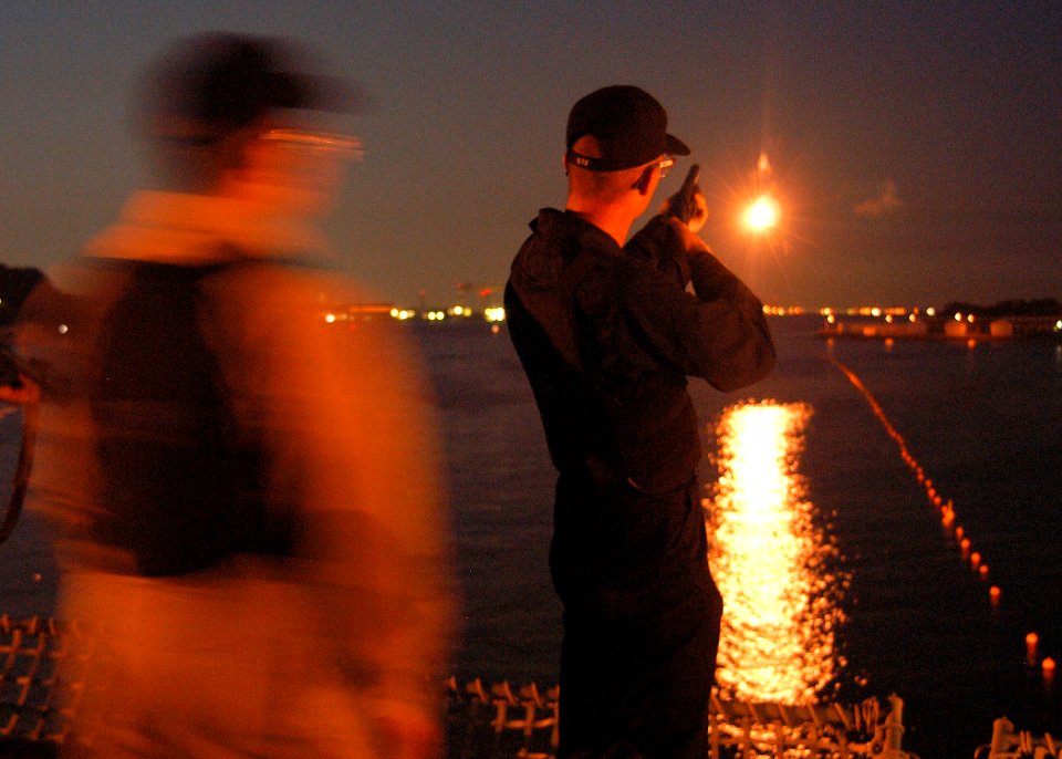 US Navy 030918-N-8955H-003 Master-at-Arms 2nd Class Dave Shull, Jr. from Orlando, Fla., shoots a non-lethal airburst device