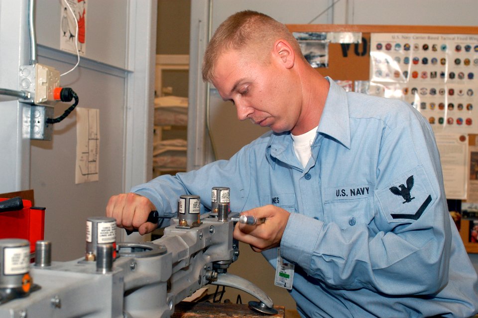 US Navy 031007-N-8770A-001 Aviation Ordnanceman 3rd Class Michael Jones assembles a bomb rack