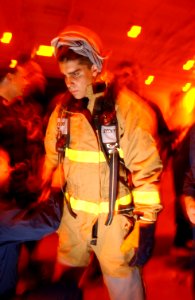 US Navy 030728-N-0696M-074 Midshipman Daren McCulley dons a firefighting ensemble during a main space fire drill aboard USS Ronald Reagan (CVN 76)