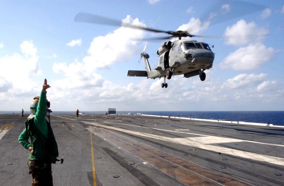 US Navy 031018-N-5821P-002 Aviation Electronics Technician 3rd Class Melissa L. Mcafee of Philadelphia, Pa., signals to the SH-60F Seahawk helicopter