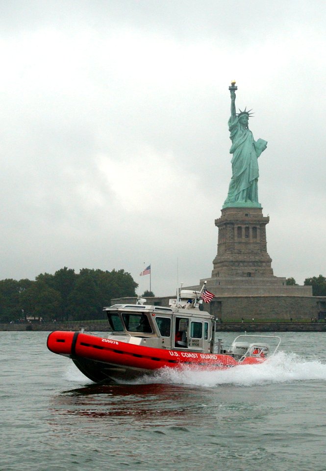 US Navy 030902-C-3948H-507 A U.S. Coast Guard boat patrols the in New York Harbor by the Statue of Liberty as part of their Homeland Security mission