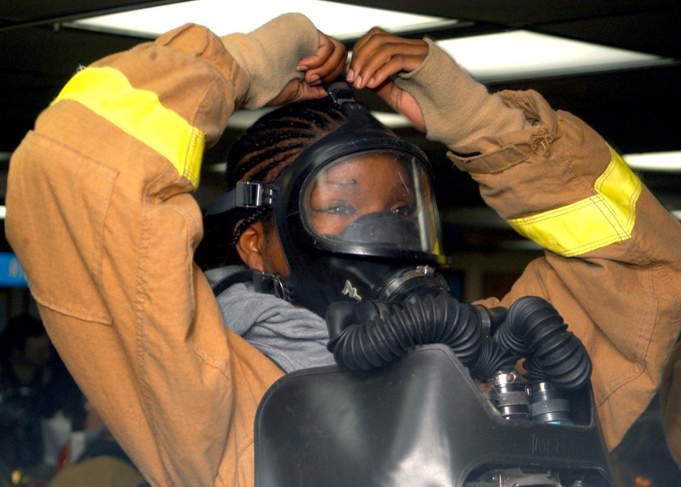 US Navy 031015-N-8955H-008 Mess Management Specialist 3rd Class Latoya Black from Detroit, Mich., tightens the upper strap of her Oxygen Breathing Apparatus