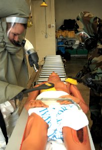 US Navy 031028-N-5297M-001 Hospital Corpsman 3rd Class Daniel St. Hilaire, left, and Hospital Corpsman 2nd Class Michael Krick demonstrate how to scrub down a chemical, biological or radiological patient during a mass casualty photo