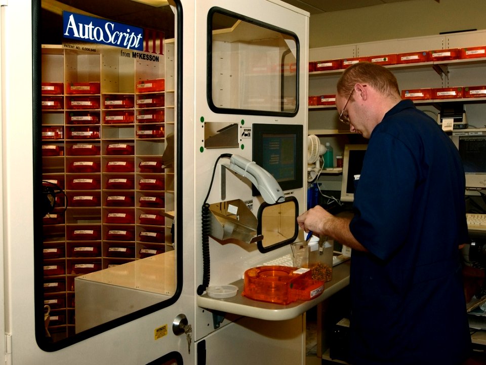 US Navy 030819-N-9593R-102 Hospitalman Randy Connelly, of Breezewood, Penna., refills a medication bin for the Autoscript III robot at the National Naval Medical Center in Bethesda, Maryland