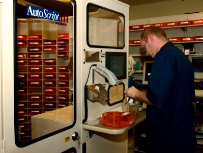 US Navy 030819-N-9593R-102 Hospitalman Randy Connelly, of Breezewood, Penna., refills a medication bin for the Autoscript III robot at the National Naval Medical Center in Bethesda, Maryland