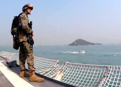 US Navy 031101-N-8955H-003 Marine Lance Cpl. Mike Anderson, from Modesto, Calif., closely watches vessels in Hong Kong harbor as USS Blue Ridge (LCC 19) departs following a four-day port call photo
