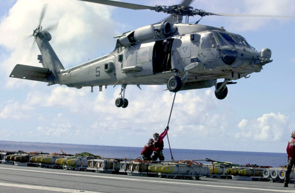 US Navy 031023-N-2385R-003 Ordnancemen assigned to USS Nimitz (CVN 68) gather ordnance for delivery to USNS Kilauea (T-AE 26) with help from an HH-60H Seahawk assigned to the Indians of Helicopter Antisubmarine Warfare Squadron Six (HS-6)
