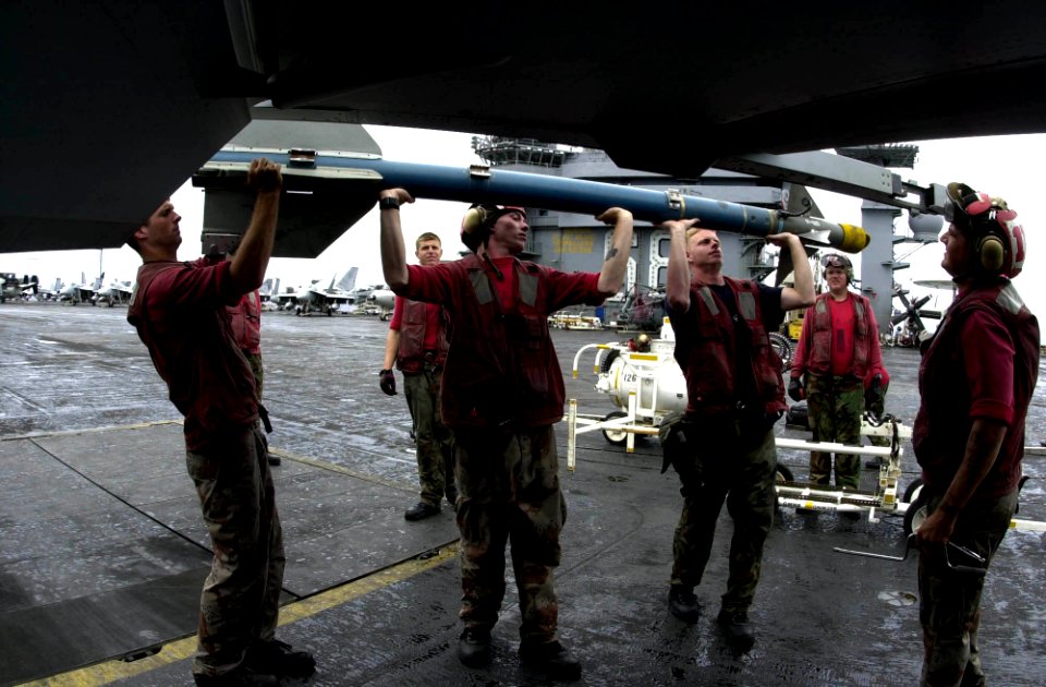 US Navy 031002-N-9319H-003 Aviation Ordnanceman assigned to the Black Aces of Strike Fighter Squadron Four One (VFA-41) prepare to arm an F-A-18F Super Hornet with an AIM-9 Sidewinder missile on the flight deck of USS Nimitz (CVN 68)