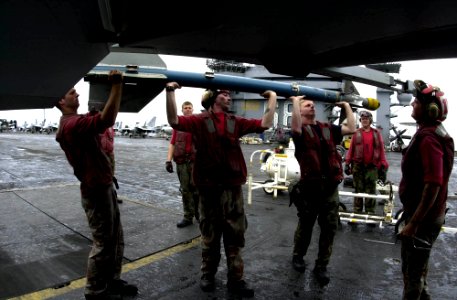 US Navy 031002-N-9319H-003 Aviation Ordnanceman assigned to the Black Aces of Strike Fighter Squadron Four One (VFA-41) prepare to arm an F-A-18F Super Hornet with an AIM-9 Sidewinder missile on the flight deck of USS Nimitz (CVN 68)