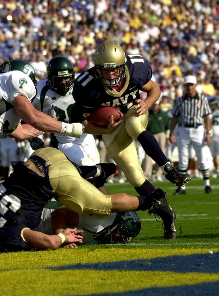 US Navy 031101-N-9693M-321 Navy quarterback Craig Condeto bounds past the Tulane defensive line enroute to a touchdown during Navy's 35-17 victory over Tulane