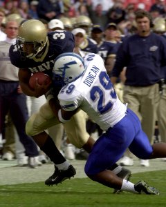 US Navy 031004-N-9693M-482 Navy slotback Eric Roberts is tackled by Air Force defender Larry Duncan