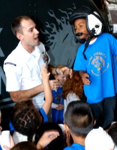 US Navy 031003-N-5821W-003 Aircrew Survival Equipmentman 1st Class Ryan Fitzgerald lets a first-grade student from Naval Air Station (NAS) Sigonella's Stephen Decatur Elementary School try on a helmet