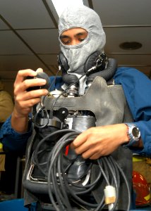 US Navy 031006-N-8955H-002 Mess Management Specialist 3rd Class Otis Salmo, from Pahala, Hi., checks his sound-powered telephone during a general quarters training drill