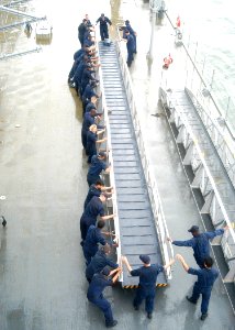 US Navy 030825-N-9860Y-008 USS Blue Ridge (LCC 19) deck department Sailors move one of the ship's brows in preparation for getting underway following a port visit