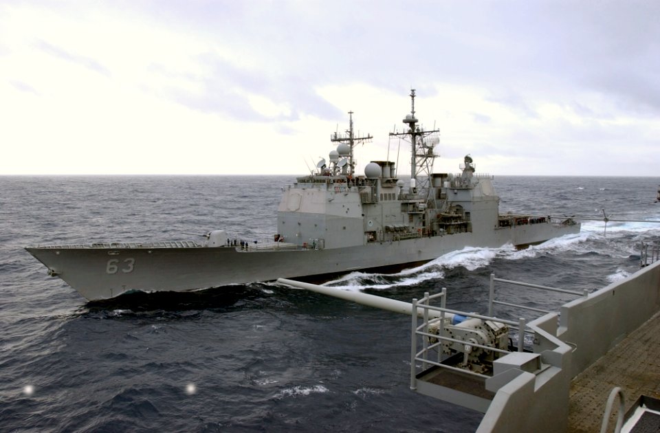US Navy 031015-N-5821P-001 USS Cowpens (CG 63) pulls alongside USS Kitty Hawk (CV 63) for replenishment-at-sea evolutions