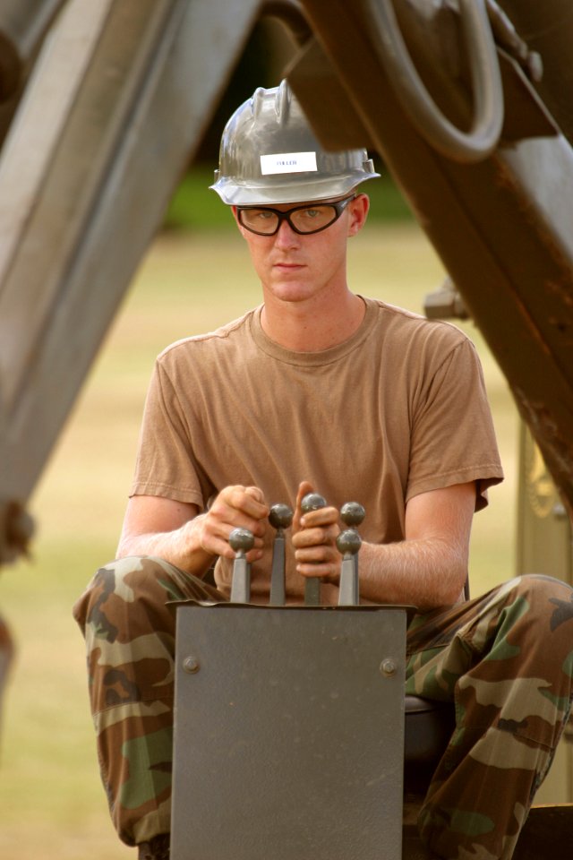 US Navy 030827-N-3228G-002 Equipment Operator Construction Apprentice Ryan Fuller assigned to Construction Battalion Unit 413 (CBU-413) removes ground cover from the lawn of the USS Utah Memorial on Ford Island with his backho