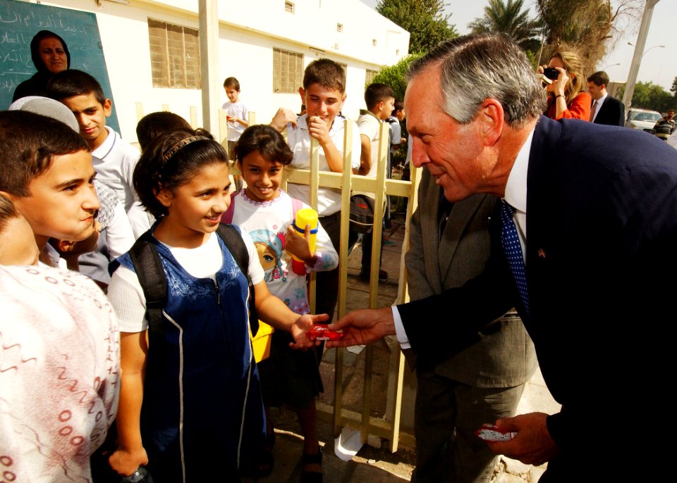US Navy 031015-N-4374S-005 U.S. Secretary of Commerce Don Evans gives a snack to an Iraqi schoolgirl during a visit to an elementary school in Baghdad, Iraq