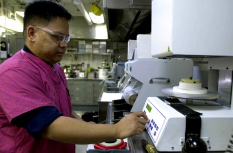 US Navy 031002-N-2143T-003 Dental Technician 2nd Class Rhoderick Mejares from San Diego, Calif., sets the porcelain oven used for baking crowns aboard USS Nimitz (CVN 68)