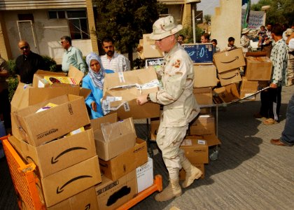 US Navy 031019-N-4374S-001 Chief Warrant Officer Paul Holton of the Utah Army National Guard, 141st Military Intelligence battalion, 3000th Brigade, loads a box of toys for children at a Baghdad children's hospital