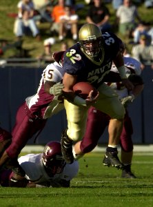 US Navy 031122-N-9693M-009 Navy fullback Kyle Eckel bounds past Central Michigan Anthony Tyus Jr. for yardage during the Midshipmen's win over the Chippewas 63-34 in Annpolis, Md