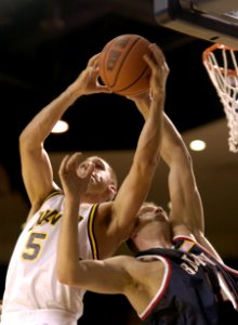 US Navy 031124-N-9693M-003 Navy sophomore guard David Hooper pulls down a rebound over Belmont senior guard Steve Drabyn during the Midshipmen's home opener at the U.S. Naval Academy