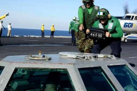 US Navy 031017-N-6278K-004 Airman Apprentice Bryan Regnier, of Rochester, Minn., shows the weight of an aircraft to catapult controls personnel