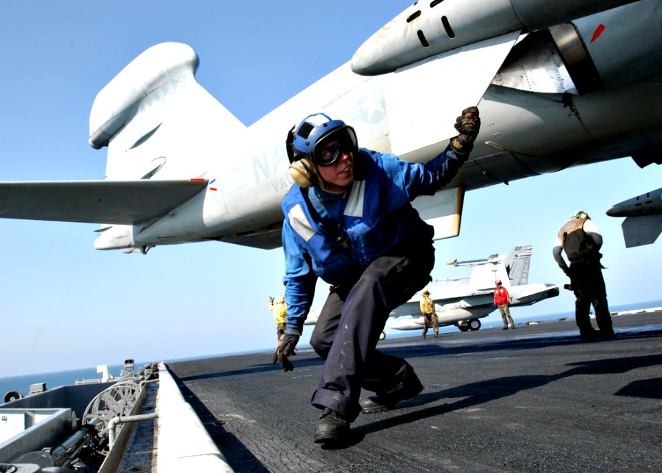 US Navy 031020-N-6187M-003 Airman Apprentice James S. Hendrickson from Belmont, W.Va. ducks under the fuselage