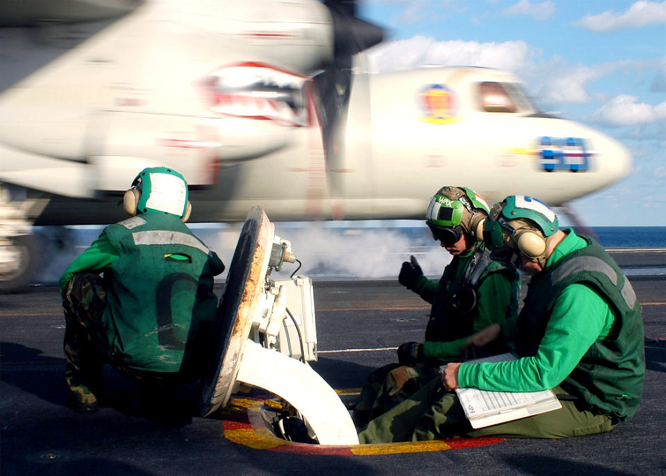 US Navy 031025-N-8213G-002 Air Department sailors assist in the launch of an E-2C Hawkeye assigned to the Bluetails of Carrier Airborne Early Warning Squadron One Two One (VAW 121)