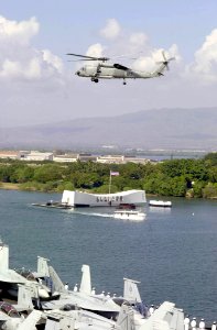 US Navy 031027-N-2385R-001 An SH-60B Seahawk assigned to the Indians of Helicopter Anti-Submarine Squadron Six (HS-6), passes by the USS Arizona Memorial while entering Pearl Harbor, Hawaii