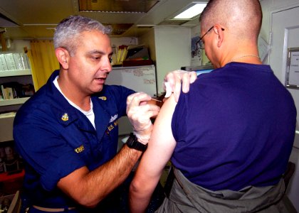 US Navy 030908-N-5471P-010 Senior Chief Hospital Corpsman Robert Johns administers Anthrax and Smallpox inoculations aboard the guided missile cruiser USS Philippine Sea (CG 58) photo