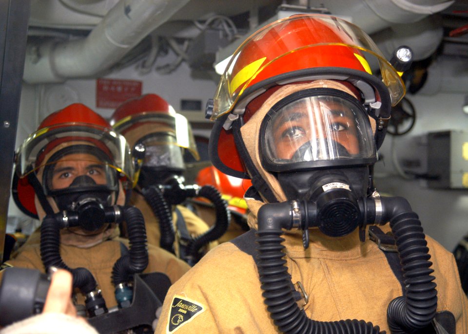 US Navy 031014-N-8955H-002 Damage Control Repair Locker One Alpha fire hose team stands ready to fight a simulated Class Bravo fire in an engine room