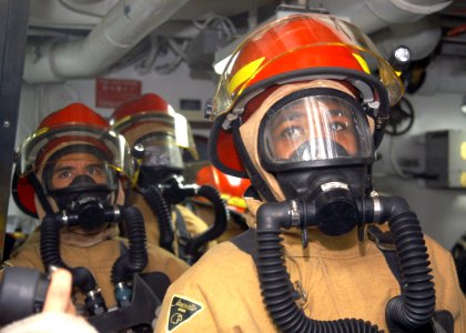 US Navy 031014-N-8955H-002 Damage Control Repair Locker One Alpha fire hose team stands ready to fight a simulated Class Bravo fire in an engine room