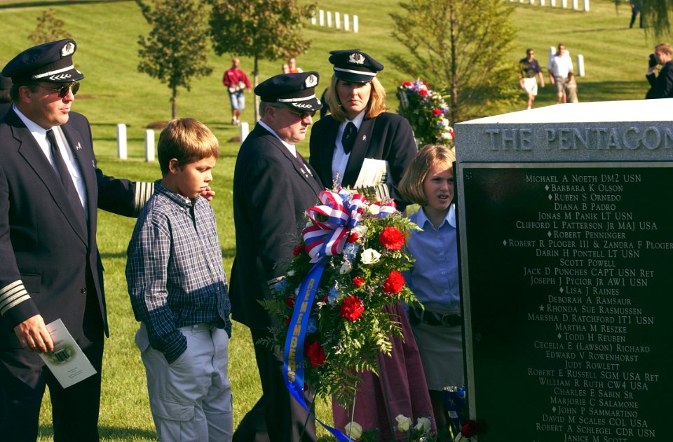 US Navy 030911-N-9593R-003 From left, American Airlines pilot James Condes and his son Christopher, join other pilots and crew looking at the names on the Pentagon Memorial in Arlington National Cemetery
