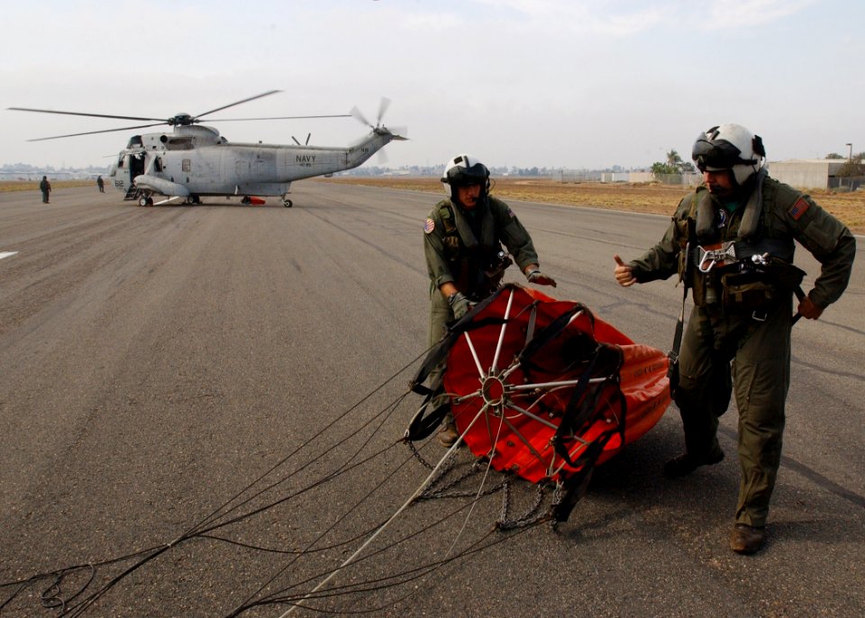 US Navy 031029-N-5067K-023 Aviation Electrician's Mate 1st Class Carl Hohenburge and Aviation Electrician's Mate 2nd Class Daryl Bellows prepare a Bambi bucket